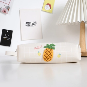 Dettaglio dell'astuccio a scacchi crema con ananas 3D in maglia e maniglia laterale