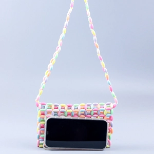 Detailed view of colorful handmade beaded bag showing acrylic beads next to a smartphone
