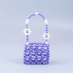 Close-up of handmade beaded handbag with light purple hollow lattice and white floral detail
