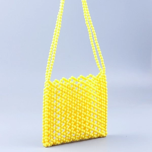 Detailed close-up of a vibrant yellow handmade acrylic beaded handbag with hollow grid structure