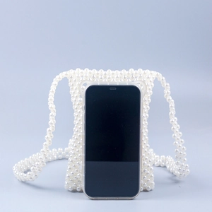 Dettaglio borsa per cellulare in perle intrecciate a mano con tracolla e smartphone