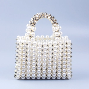 Macro detail of handmade pearl beaded handbag with metallic accents and rounded handle