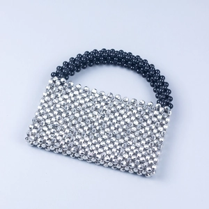 Macro shot of silver faceted beads and black round bead handle of a handmade handbag
