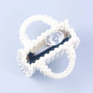 Handmade white faux pearl beaded handbag with square woven design on blue background