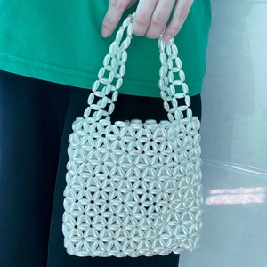 Detailed view of handmade white pearl woven handbag with floral bead pattern