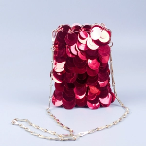 Détail d'un sac à bandoulière en paillettes rouges avec chaîne dorée et effet brillant