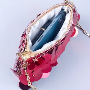 Macro view of red sequin evening clutch showing interior capacity for phone and lipstick