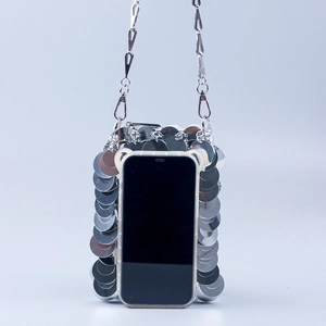 Détail du sac de téléphone à paillettes argentées montrant la texture métallique