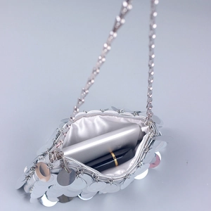 Silver sequin crossbody evening bag with chain strap showing phone and lipstick storage