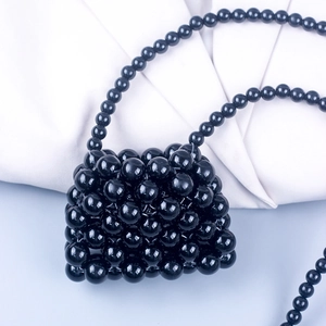 Detailed macro shot of handmade black beaded mini bag showing high-gloss resin bead texture
