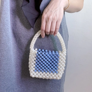 Close-up of blue and white acrylic beaded mini handbag with handmade weave detail