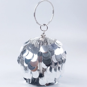 Detailed view of silver spherical evening bag featuring large metallic sequins and a round handle
