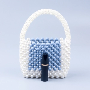 Detail view of blue and white beaded handbag with lipstick for size scale reference