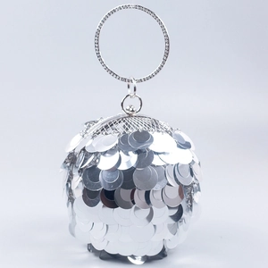 Close-up of a silver spherical evening bag with layered sequins and a rhinestone metal ring