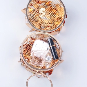 Interior view of a golden sequin evening clutch showing space for perfume and lipstick