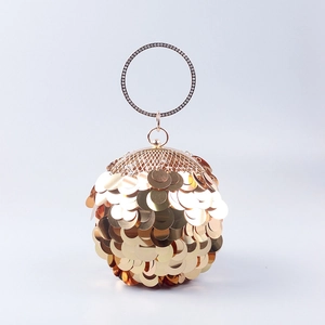 Macro view of metallic sequins and rhinestone-encrusted ring handle on the evening bag