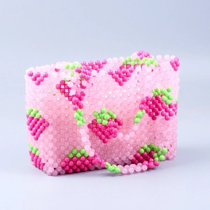Détail d'un sac à main fait main en perles roses avec motifs de fraises