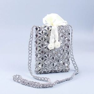 Detail of silver beaded crossbody bag with hollow floral pattern and satin drawstring pouch