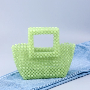 Texture détaillée du sac à main en perles acryliques vert menthe sur un jean bleu