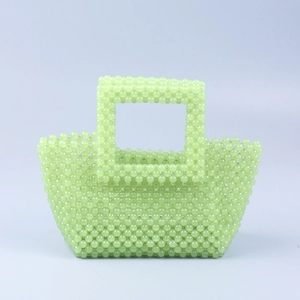 Détail du tissage de perles en acrylique vert menthe fait main sur le sac à main carré