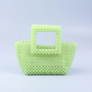 Détail du tissage de perles acryliques vert menthe et de la poignée carrée du sac à main