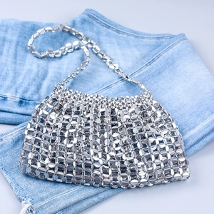 Detailed view of silver metal sequins and ring links on a trendy shoulder bag