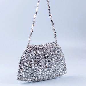 Detail of silver metallic disc sequins and ring chain strap on handmade shoulder bag