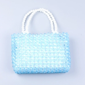 Detail of hand-woven light blue acrylic beads and double-layer pearl handles on a square bag