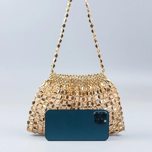 Detailed view of handmade gold beaded woven handbag with phone for size reference