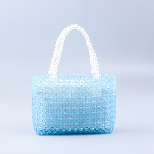 Detailed view of handmade blue acrylic beaded bag with double white pearl handles