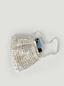 Detail view of woven beaded handbag featuring large round sequins and pearl trim accents