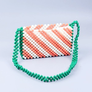 Detailed close-up of handmade acrylic beaded bag with orange and white diagonal stripes