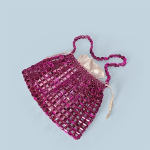 Macro detail of hand-woven purple sequins and smooth satin lining on a luxury evening clutch