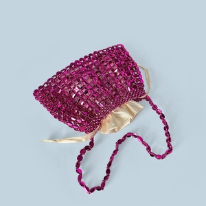 Detail of rose red sequin mesh handbag with golden satin drawstring pouch inside