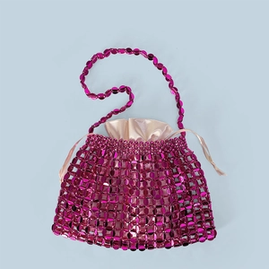 Detail of fuchsia metallic sequin woven handbag with champagne satin drawstring liner