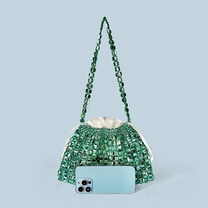 Macro shot of green beaded shoulder bag showing translucent discs and satin inner pouch