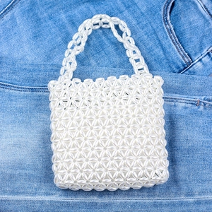 Elegant white pearl beaded handbag with floral weave texture and dual top handles