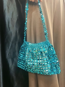 Detailed close-up of handmade electric blue beaded woven shoulder bag with mesh texture