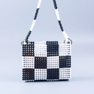 Detail of handmade beaded bag showing black and white checkered pattern and metal rings