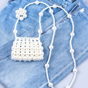 Mini sac bandoulière fait main en perles avec détail floral sur fond en denim