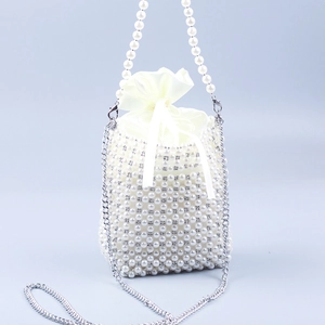 Detail of a handmade pearl woven bucket bag with satin drawstring and silver chain strap
