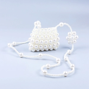 Détail du mini sac bateau fait main en perles avec breloque fleur et bandoulière