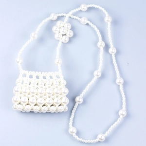Détail du sac à bandoulière tissé en perles avec chaîne fleurie et texture blanc nacré