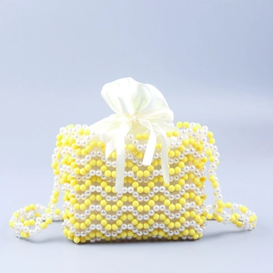 Détail du sac perlé fait main jaune et blanc avec une pochette interne en satin à cordon
