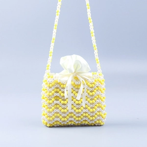 Détail du sac bandoulière en perles fait main avec motif vagues jaune blanc et sac en satin