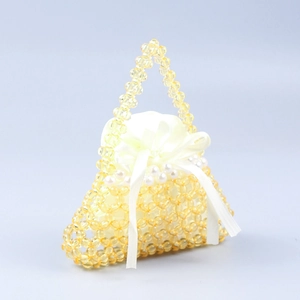 Dettaglio borsa a mano con perline gialle, interno in raso bianco e fiocco decorativo