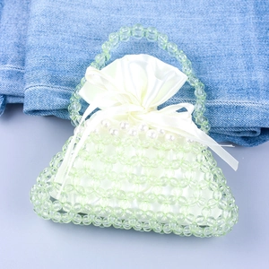 Dettaglio borsa a mano con perline verde chiaro e fodera in raso bianco a coulisse