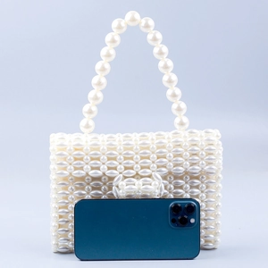 Elegant white faux pearl woven handbag with top handle and smartphone size reference