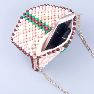 Elegant beaded crossbody bag with pink floral pattern, gold chain and interior capacity view