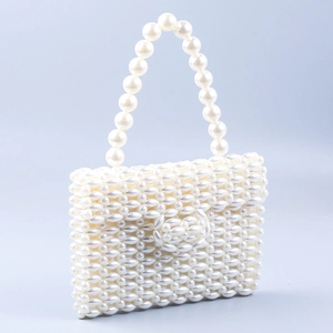 Detailed view of the intricate hand-woven pearl pattern on this elegant evening handbag